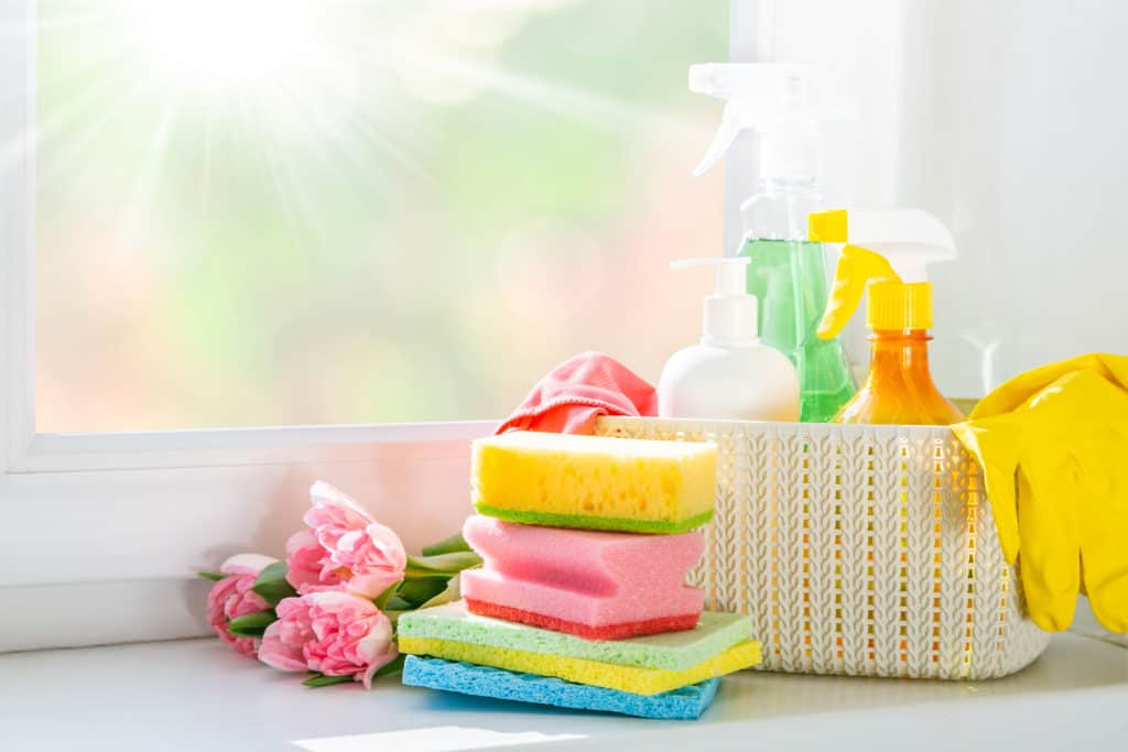 Spring cleaning essentials - cleaning products, gloves, bokeh background, copy space